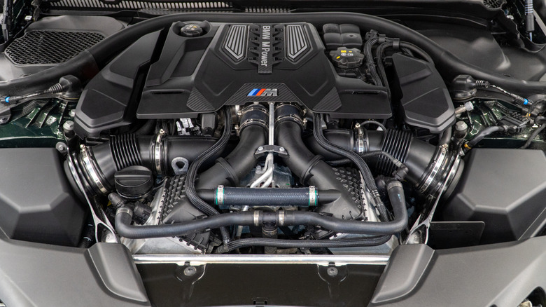 Open hood of a BMW revealing twin-turbocharged engine bay