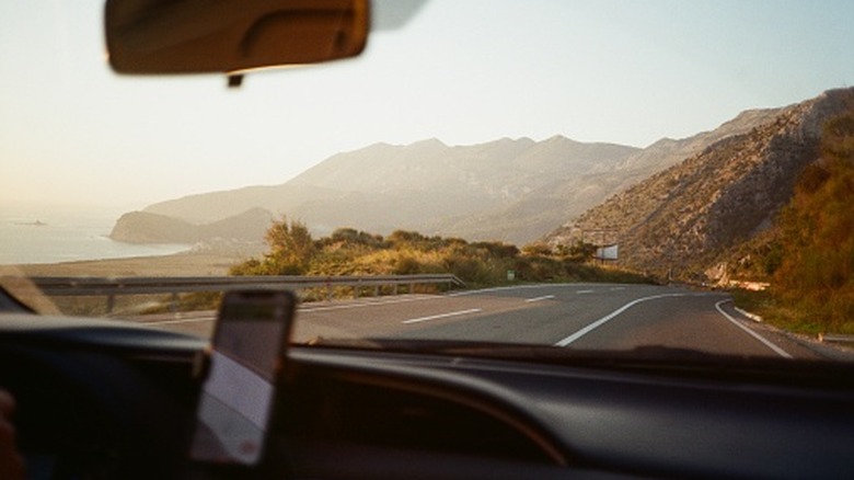 Point of view from inside a car driving near the seashore.