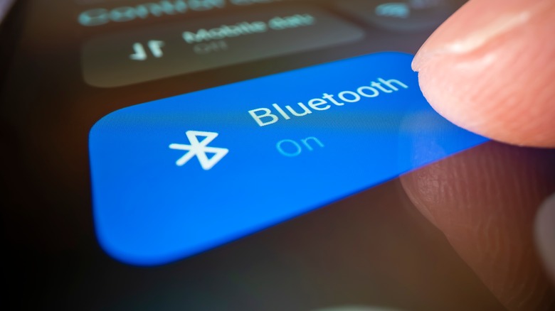 finger pressing bluetooth on button