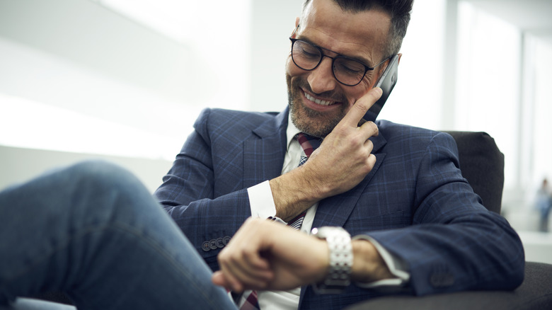 Man on phone, looking at watch