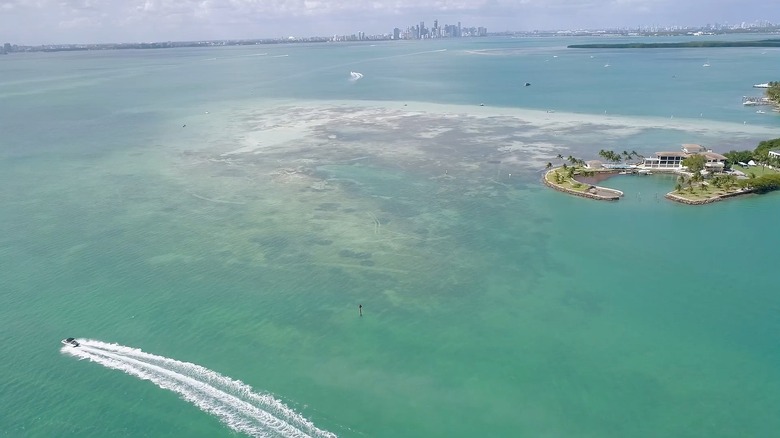 An aerial image of a boat navigating near a large sandbar