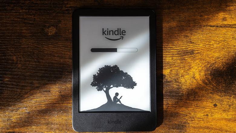 Kindle laying on a wooden table with a loading screen