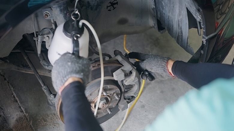 Mechanic bleeding air out of a brake system