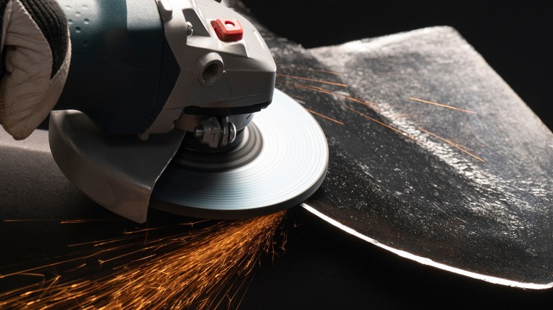 Sharpening a shovel with an angle grinder.