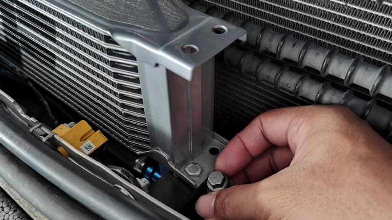 Mechanic installing an oil cooler