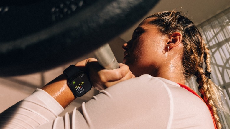 Person lifting weights while wearing new Apple Watch.