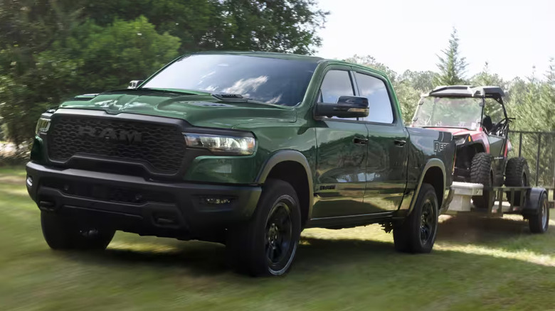 Hero shot of a 2026 Ram 1500 towing a golf mobile on a single axle trailer