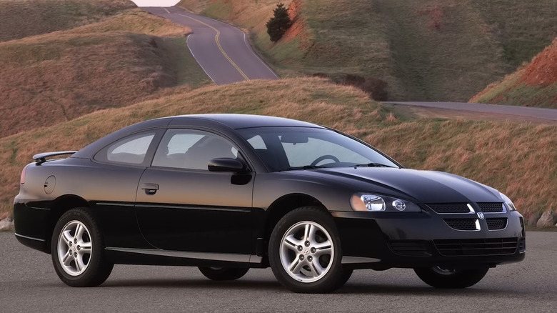 Black Dodge Stratus R/T ion a country road.