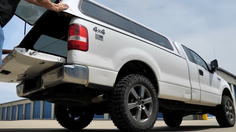 People installing a truck topper on a pickup