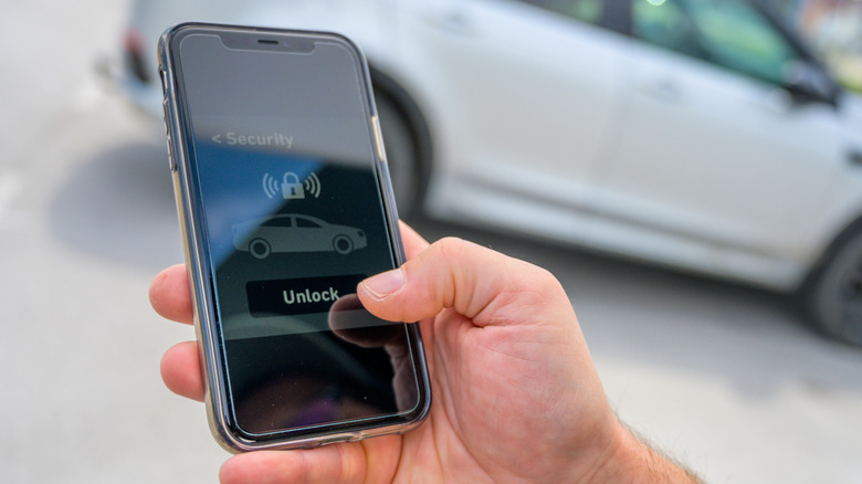 Man using a cell phone to unlock a car