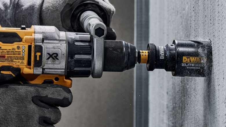 Person using DeWalt driver with cutting carbide bit on concrete