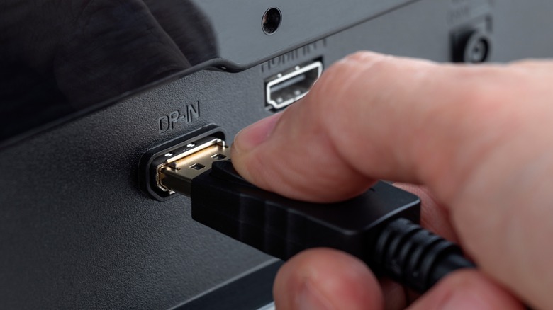 DisplayPort cable being connected to a compatible port on a Television