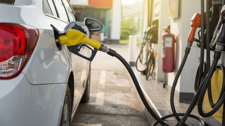 A white Chevrolet Cruze being refuelled at a gas station
