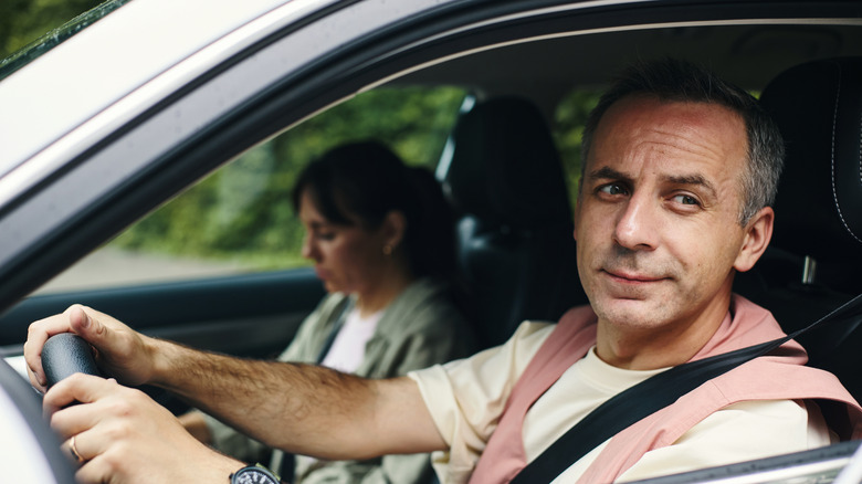 A man driving with an open window