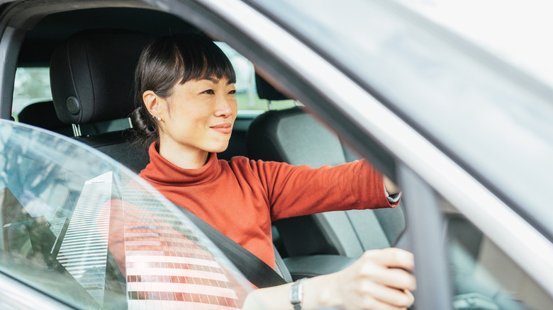 woman driving a car  with the window half opened