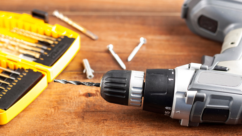 Power drill and bits on wood table