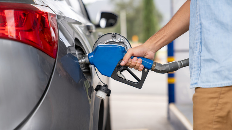 Close up of hand filling up car with gas