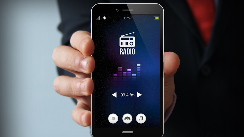 hand holding phone with FM Radio app