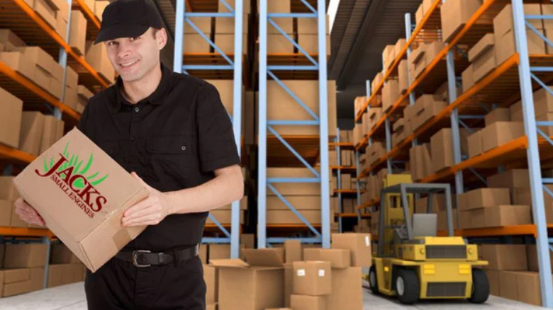 Man holding box with Jacks Small Engines logo in a warehouse