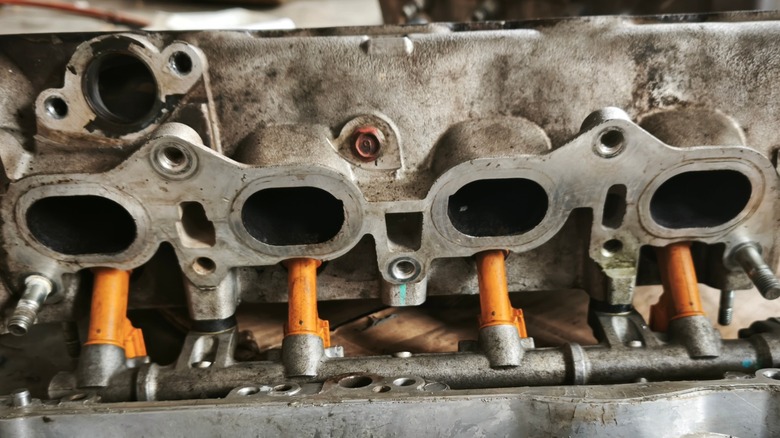 A disassembled intake manifold on a work bench.