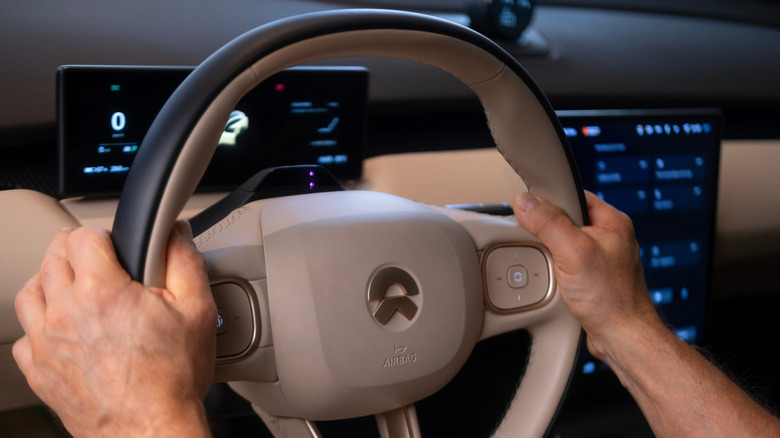 Driver's hands at 9 o'clock and 3 o'clock positions on steering wheel