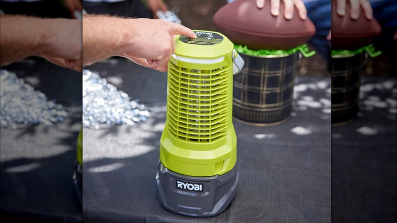 person pressing button on Ryobi Bug Zapper