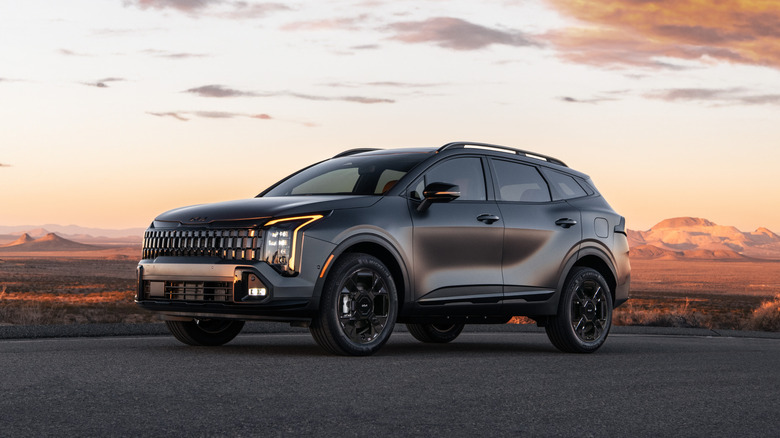Front 3/4 view of a black 2026 Kia Sportage at sunset