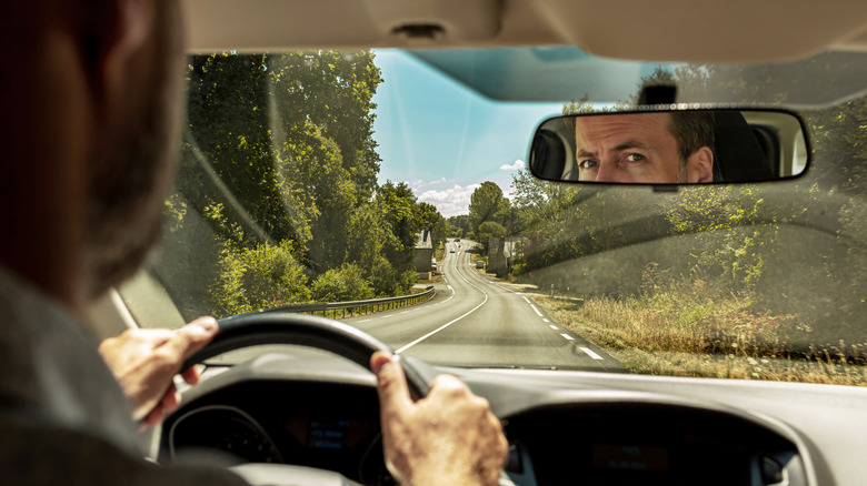 Person looking at rearview mirror with perfect windshield