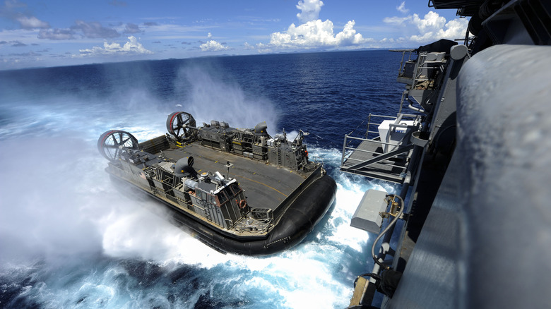 An LCAC in the wake of an amphibious assault ship