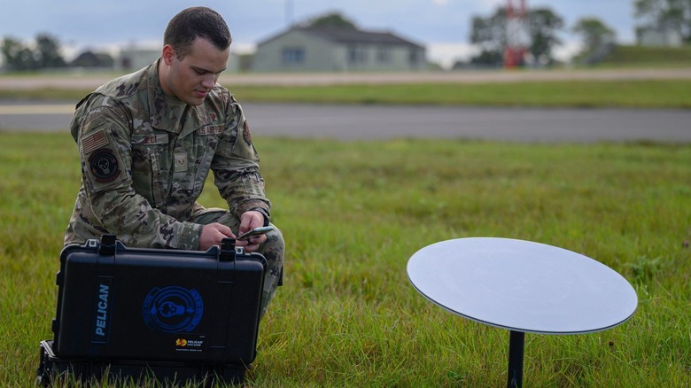A member of the U.S. Air Force operates a Starlink terminal