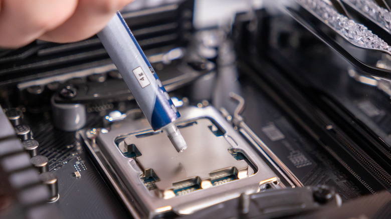 A person applying thermal paste to a CPU