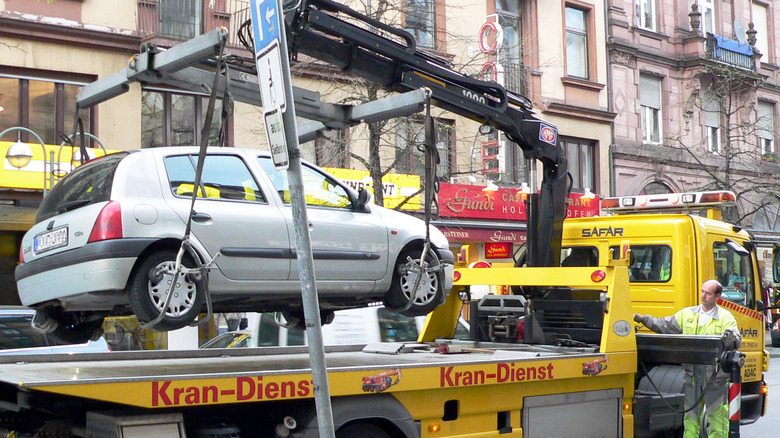 vehicle getting jerked up a tow truck in street