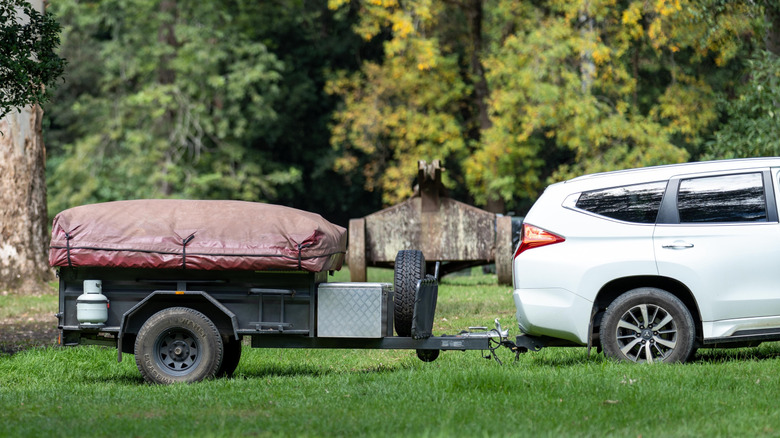 A camper trailer being towed by an SUV