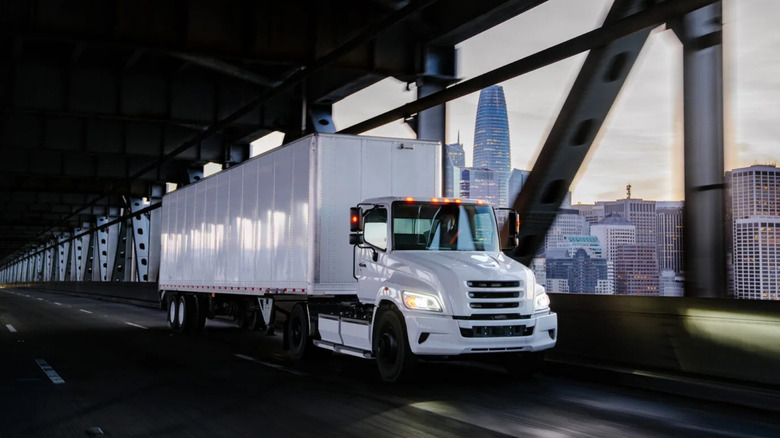 Hino electric truck and trailer on lower deck of bridge, front-right three-quarter view