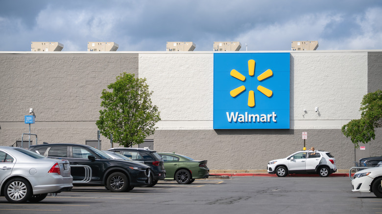 Parking lot full of cars in front of a Walmart store.