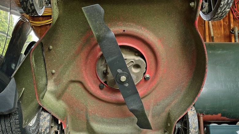 A lawn mower tilted to show its blade.
