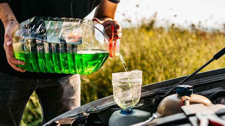 Man pouring wiper fluid in reservoir