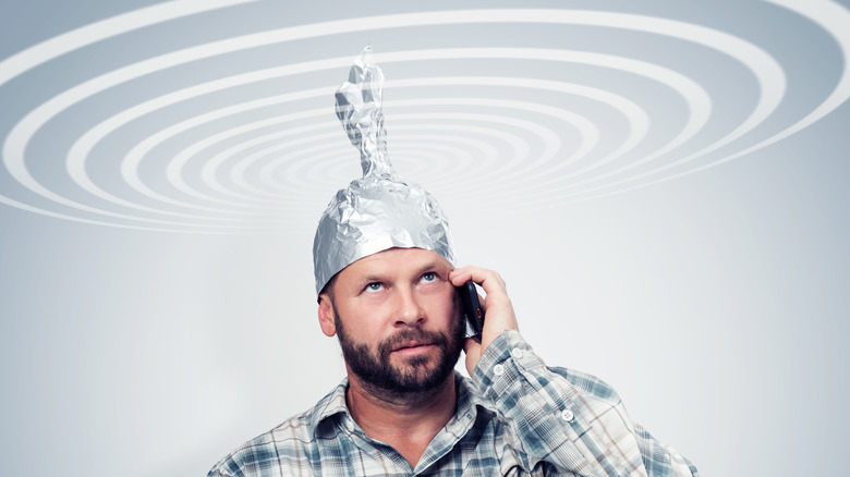 man with tin foil hat on phone