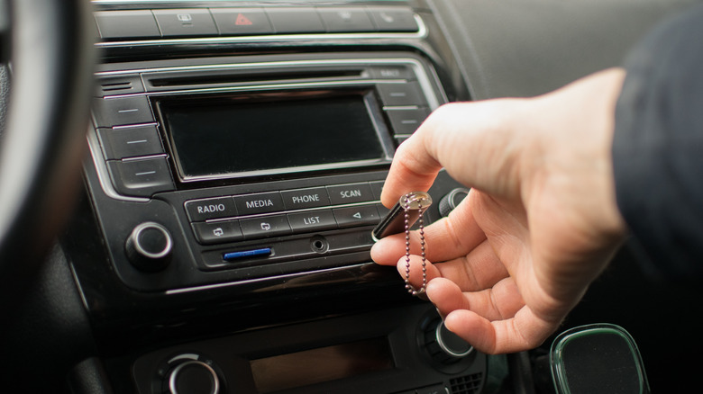 a person inserting a USB-C flash drive into a dashboard's USB-C port