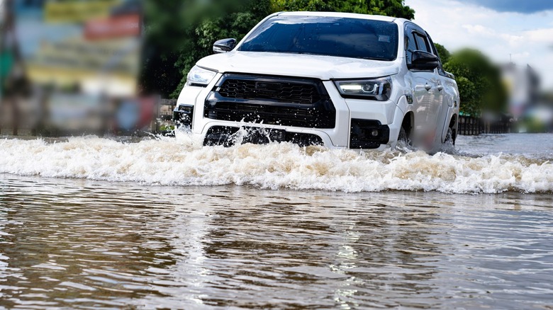 White truck driving through flood