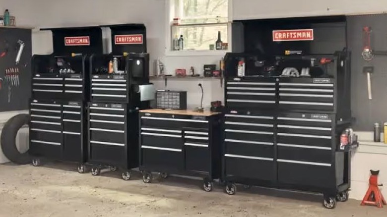 Several black tool boxes lined up along a garage wall