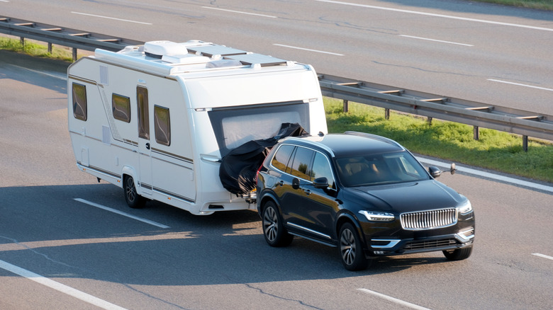 SUV towing a large trailer on a highway
