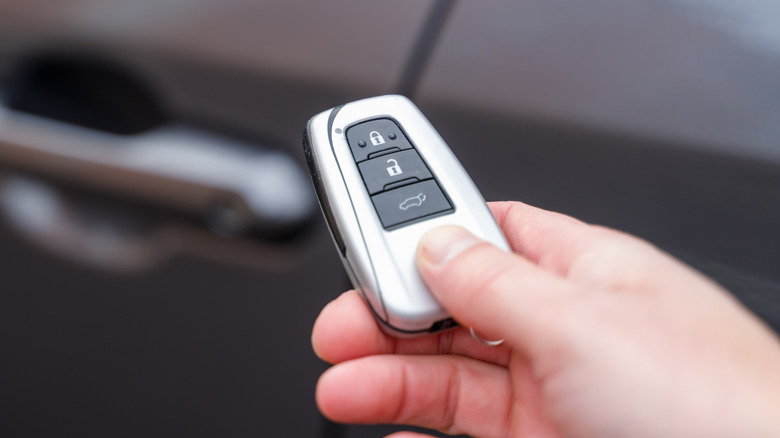 A person holding a car key fob.