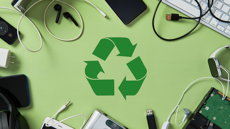 Old electronics and cables with recycling icon in the center