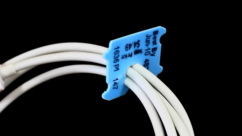 A wrapped white cable held by a blue bread tag.