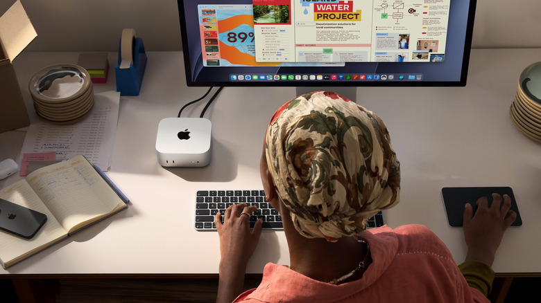 Person using a Mac mini with wireless keyboard the apple magic trackpad