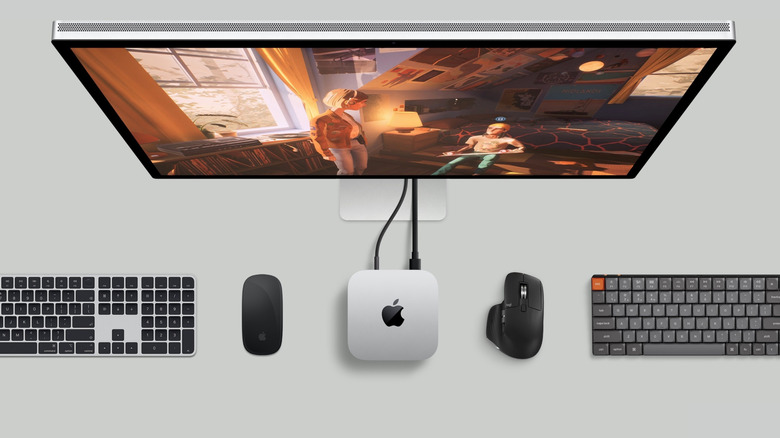Mac mini connected to a Mac screen alongside various keyboards and mouse accessories