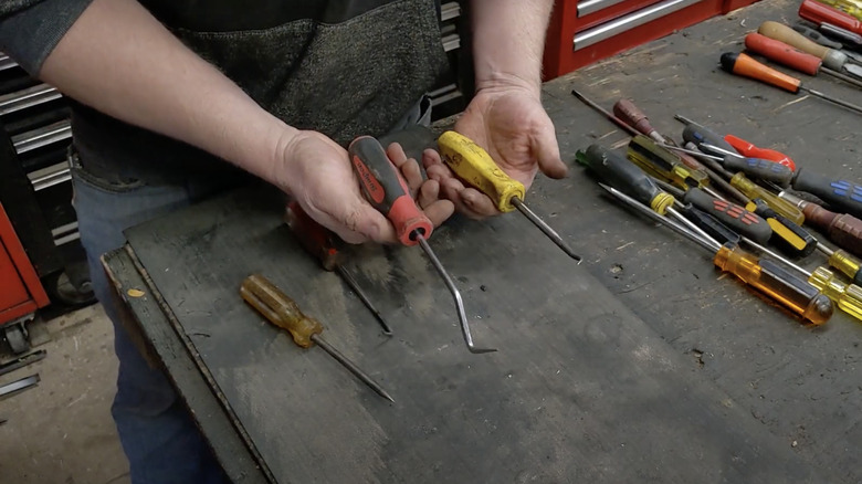 man holding screwdrivers turned into picks