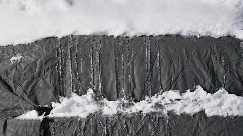 Composition of snow and ice on a black tarp
