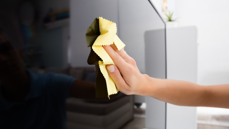 woman wiping tv screen